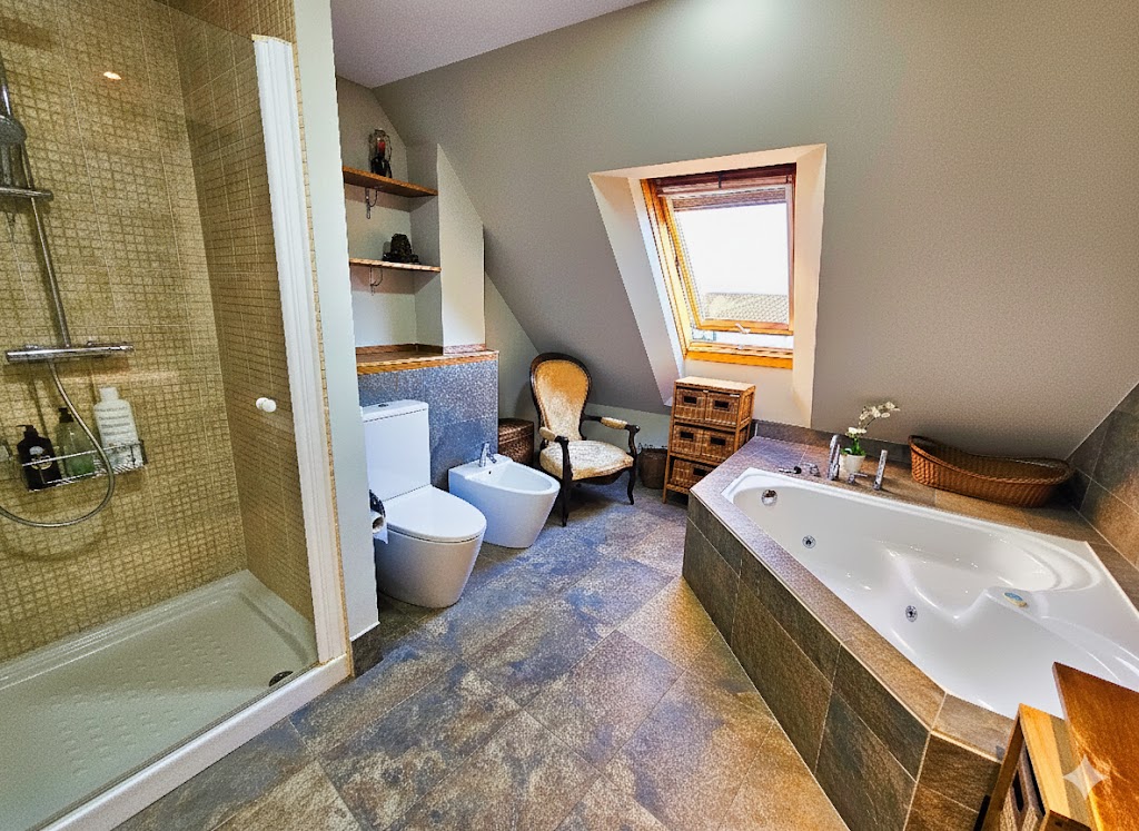 Baño suite principal con jacuzzi angular, bidé, ducha independiente, claraboya con luz natural, suelo de terrazo y decoración elegante