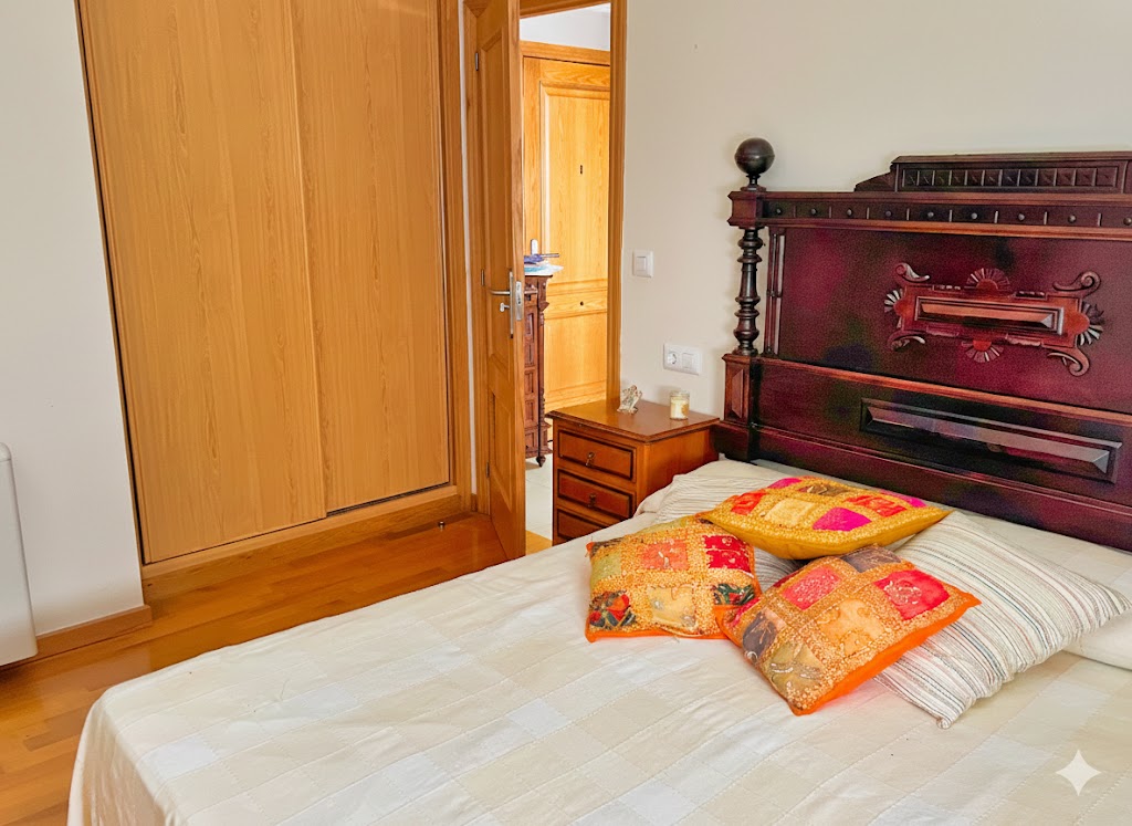 Dormitorio doble con cama de matrimonio, cabecero de madera tallada, armario empotrado y textiles de calidad