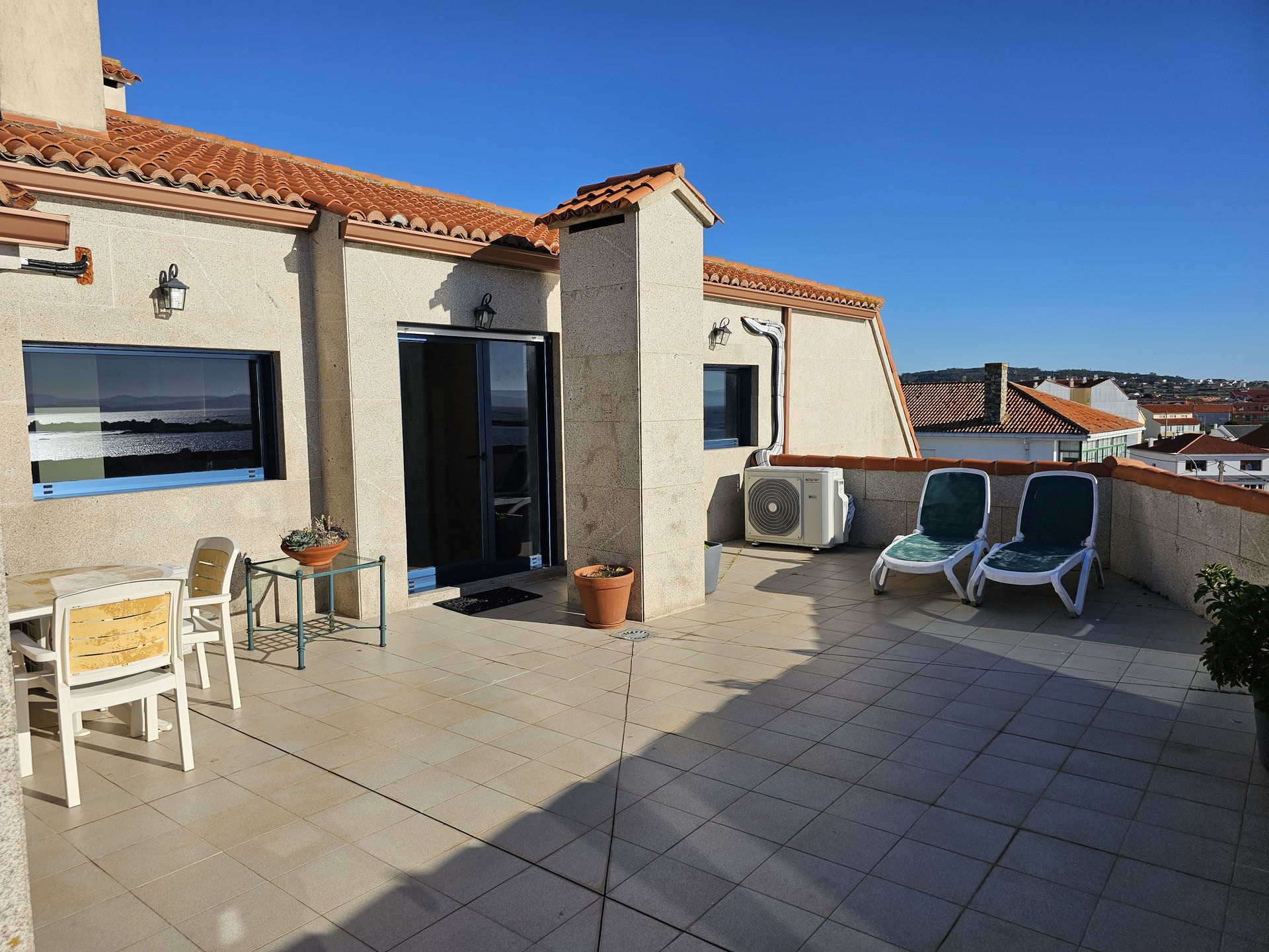 Fachada exterior del ático con terraza privada y vistas al puerto de Aguiño